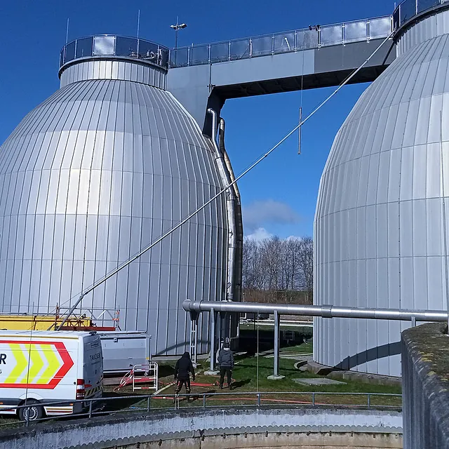 Große zylindrische Industriebehälter mit Rohrleitungen und Verbindungsgang als Einsatzbereich für technische Spezialarbeiten von TAI-TECH PRO.